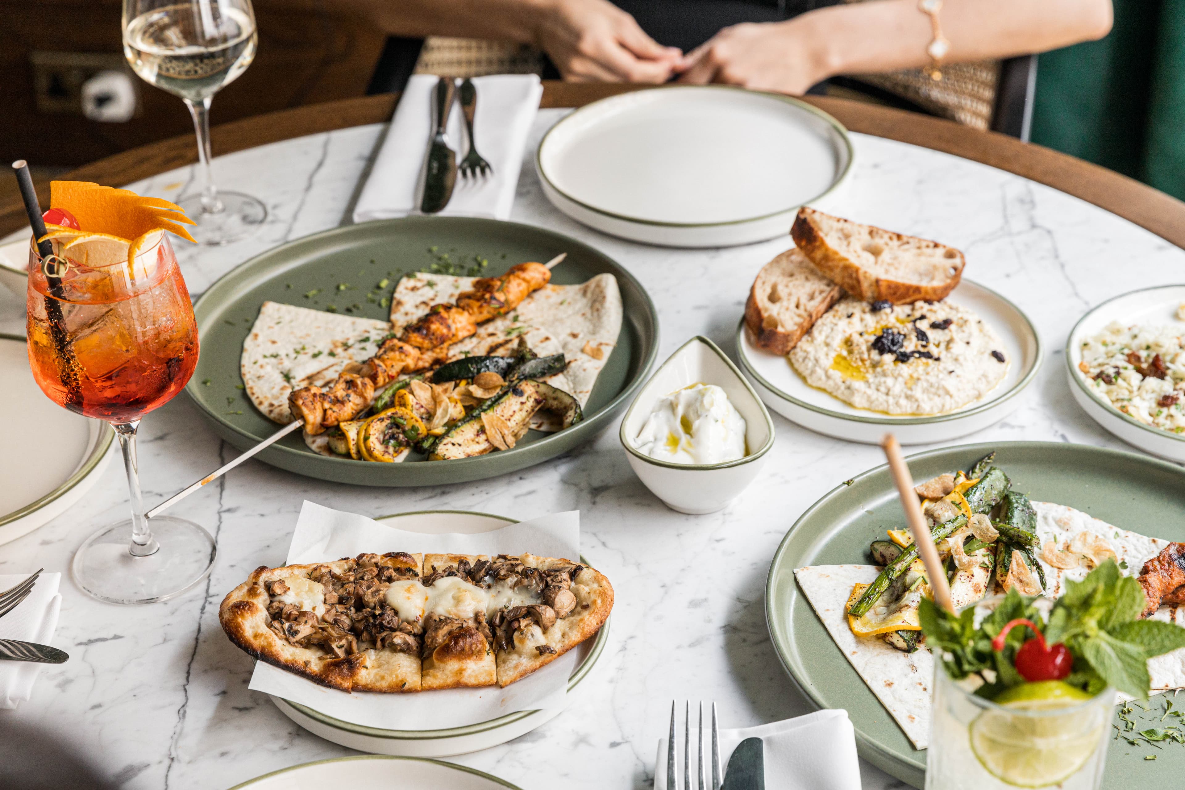A table of Mediterranean sharing dishes, wine and bread at Olea Social